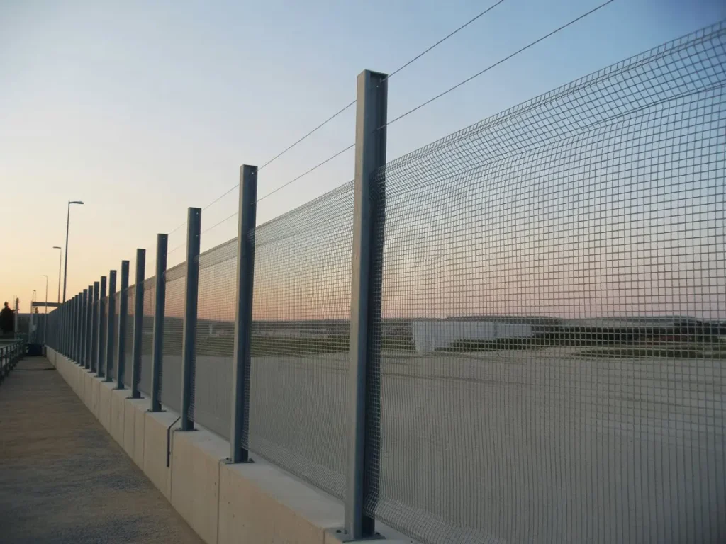 instalacion-vallados-proteccion-ribaroja vallado de proteccion con malla metalica y postes sobre muro en instalacion en ribaroja
